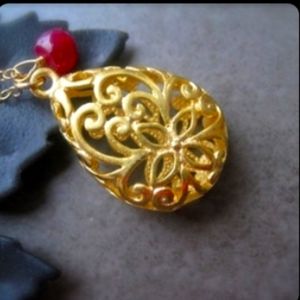 Filigree gold pendant with ruby
